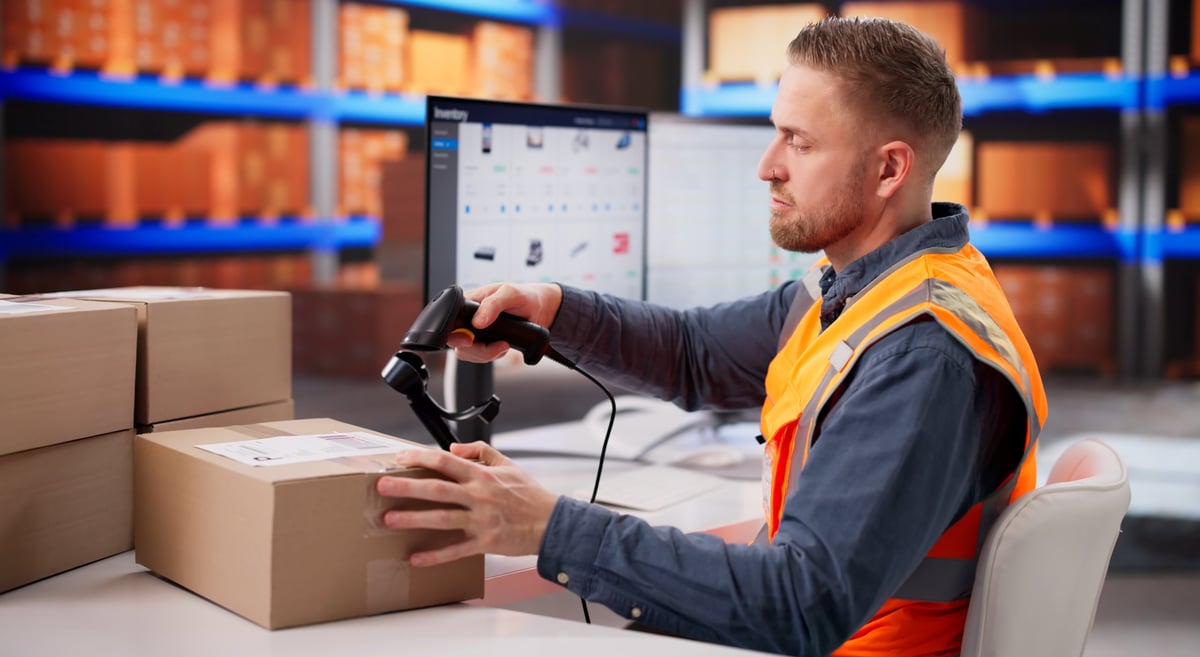 Warehouse Employee Checking Barcode Tags On Boxes For Stock Management