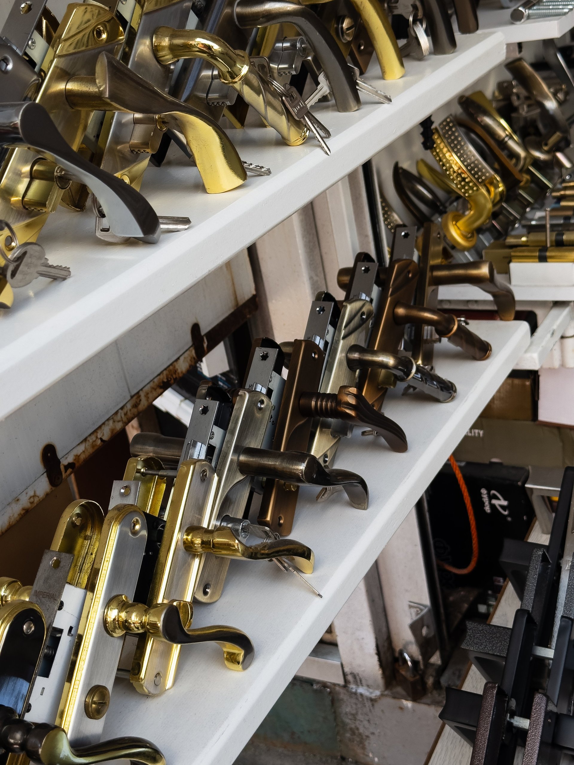 Door handles and locksets displayed on shelves in hardware store